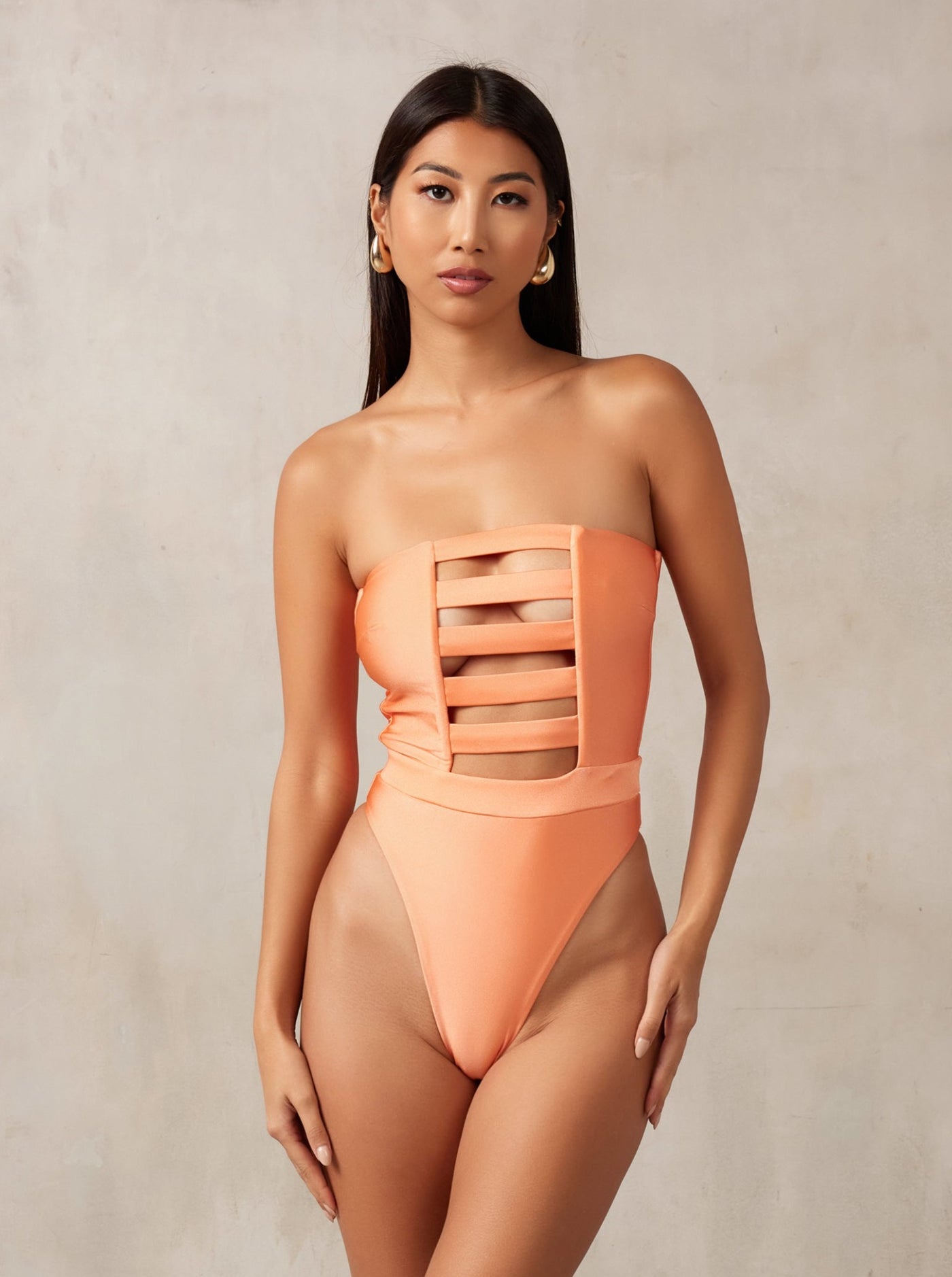 MBM Swim, Marcia B Maxwell high-cut peach coral cut-out one-piece swimsuit on beautiful model, black owned #color_coral