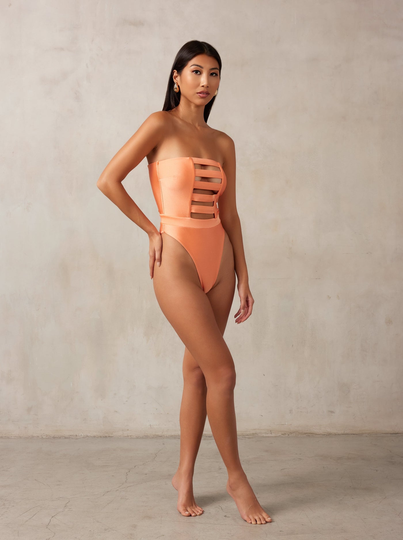 MBM Swim, Marcia B Maxwell high-cut peach coral cut-out one-piece swimsuit on beautiful model, black owned #color_coral