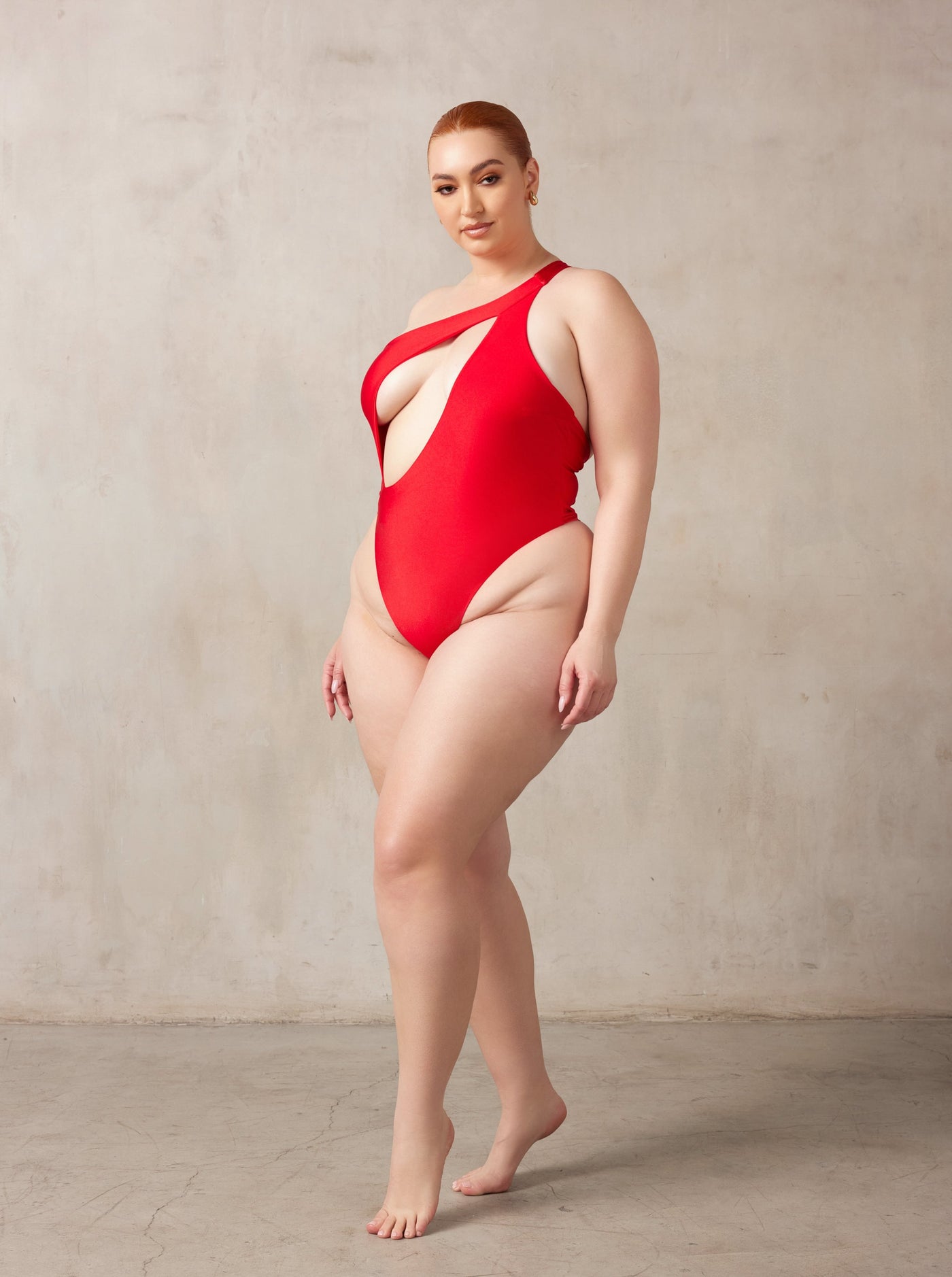 Curve midsize model wearing MBM Swim by Marcia B Maxwell Serenity red one-piece one-shoulder swimsuit #color_red