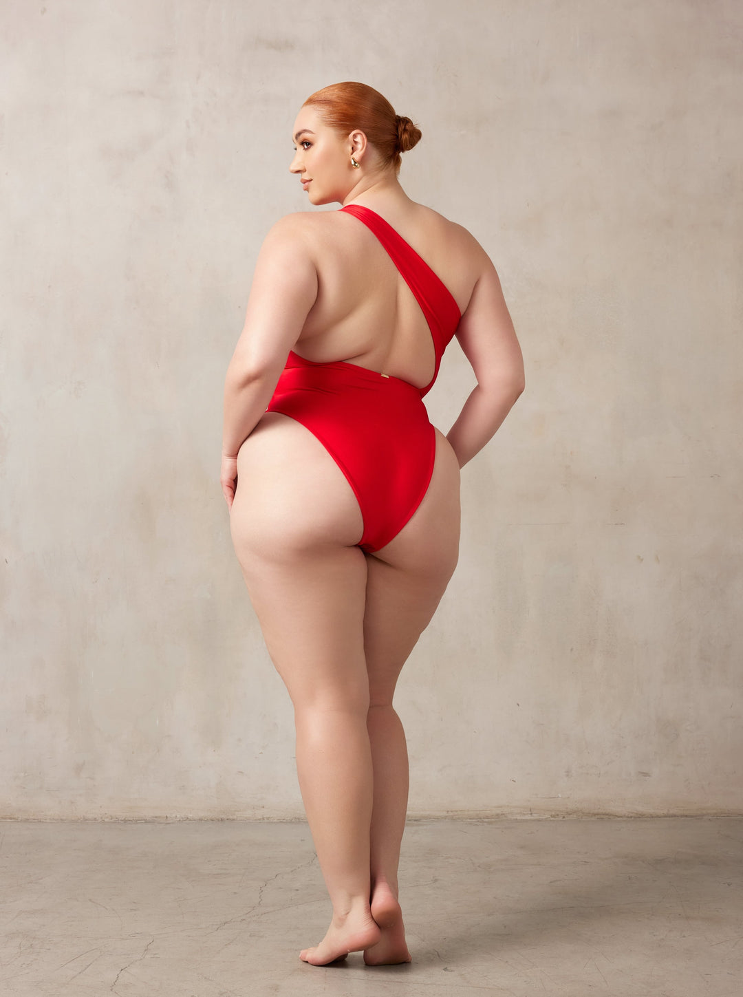 Curve midsize model wearing MBM Swim by Marcia B Maxwell Serenity red one-piece one-shoulder swimsuit #color_red